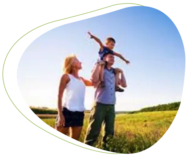 A family is standing in the grass with one child.