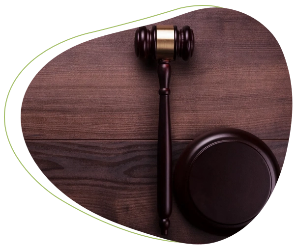 A wooden judge 's gavel and a round object on top of a table.