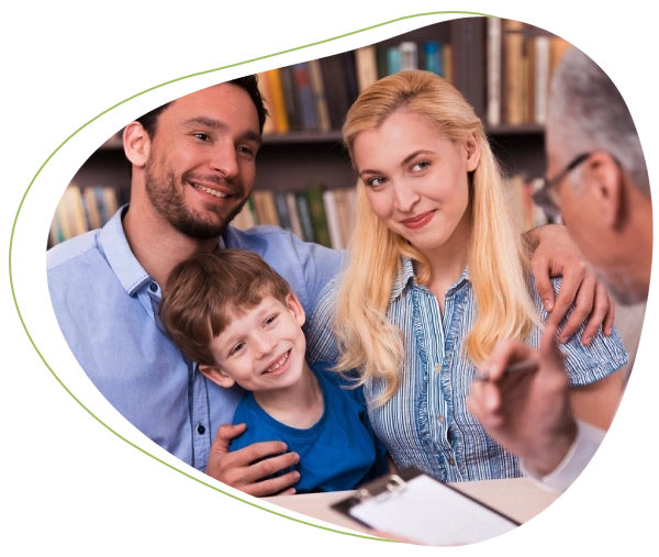 A family is smiling for the camera in front of some books.